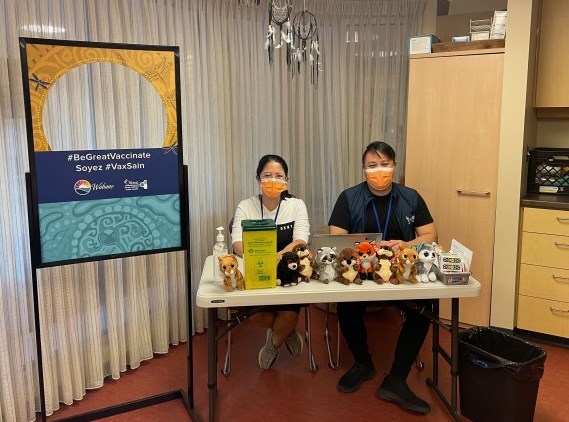 Two immunization staff at Wabano wearing orange masks