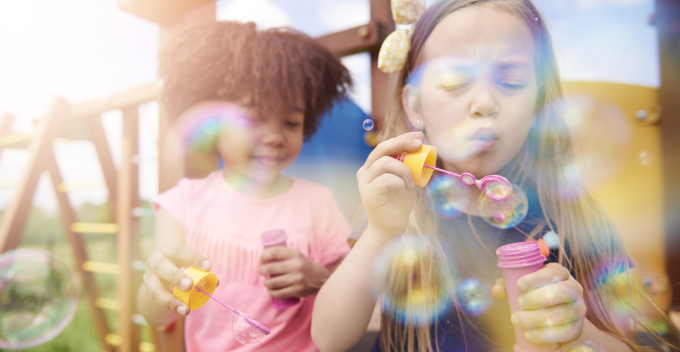 Two children blowing bubbles