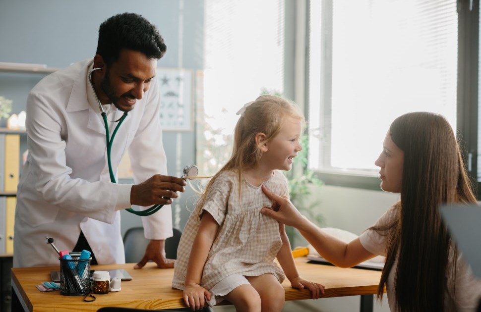 Photo d'un pédiatre communautaire avec un patient et sa mère.
