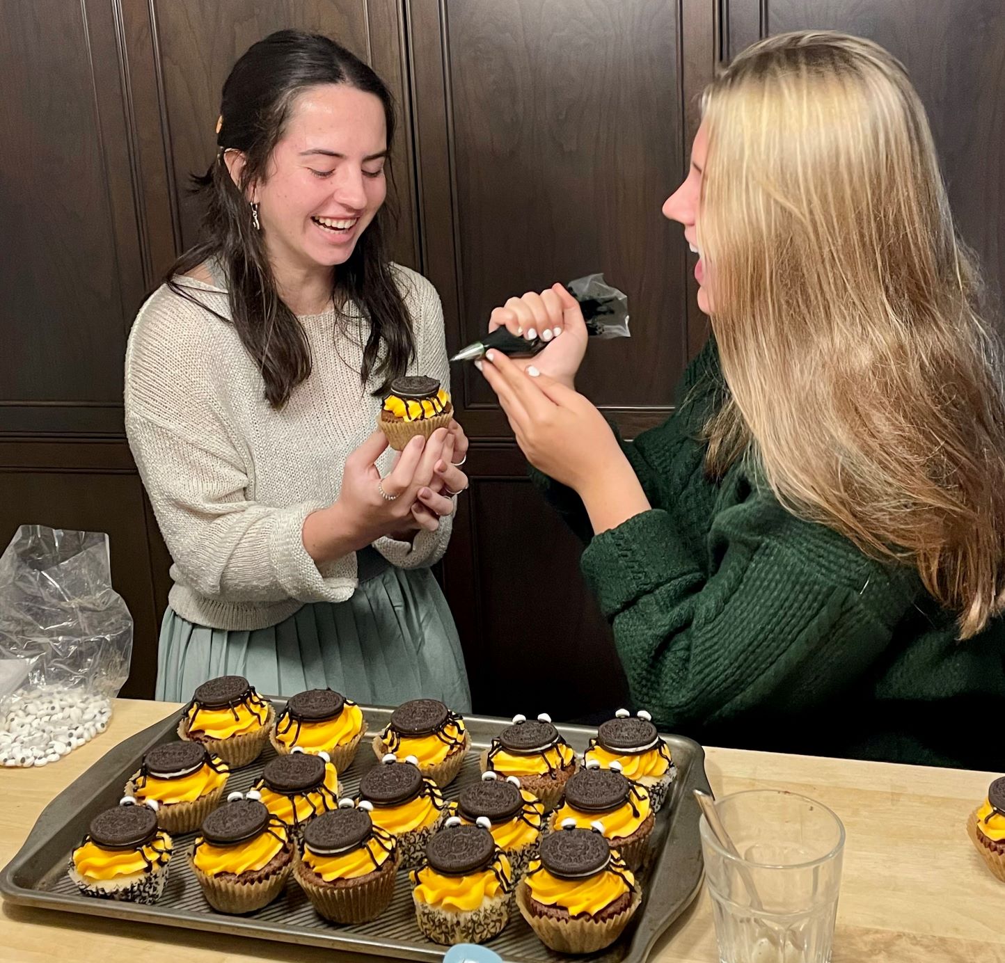 two youth having fun with halloween cupcake decorating