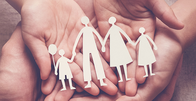 Hands holding a family paper people chain